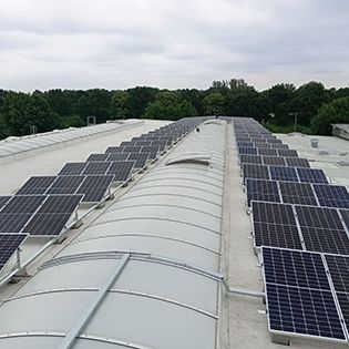 panele fotowoltaiczne zamontowane na dachu hali produkcyjnej