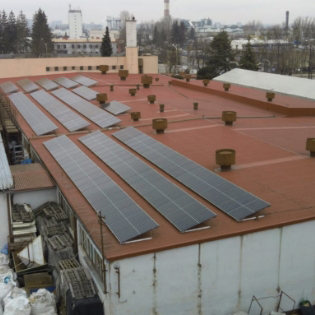 panele fotowoltaiczne na dachu budynku produkcyjnego