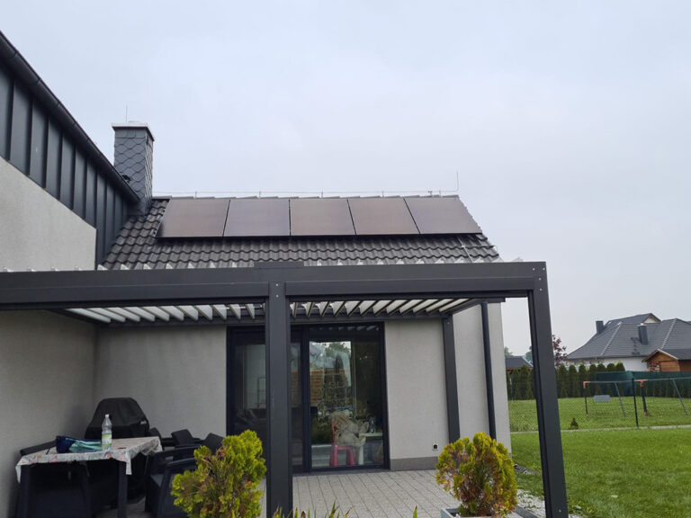 Instalacja czarnych paneli słonecznych na dachu nowoczesnego domu jednorodzinnego w Opolu